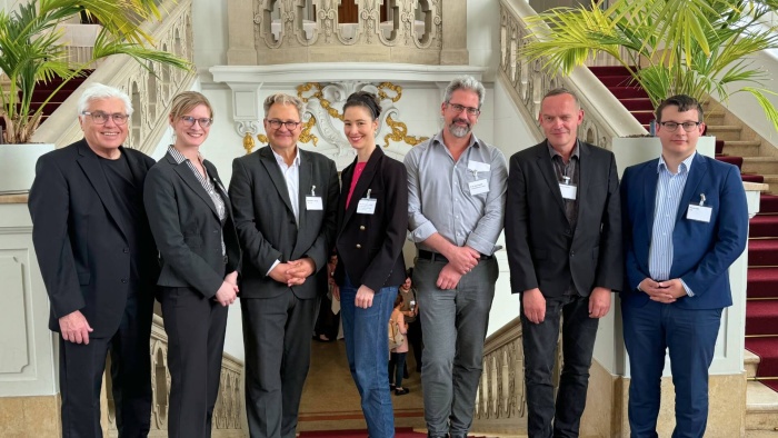 Opt-out-Workshop Mehrere Personen stehen in einer Reihe nebeneinander und lächeln in die Kamera